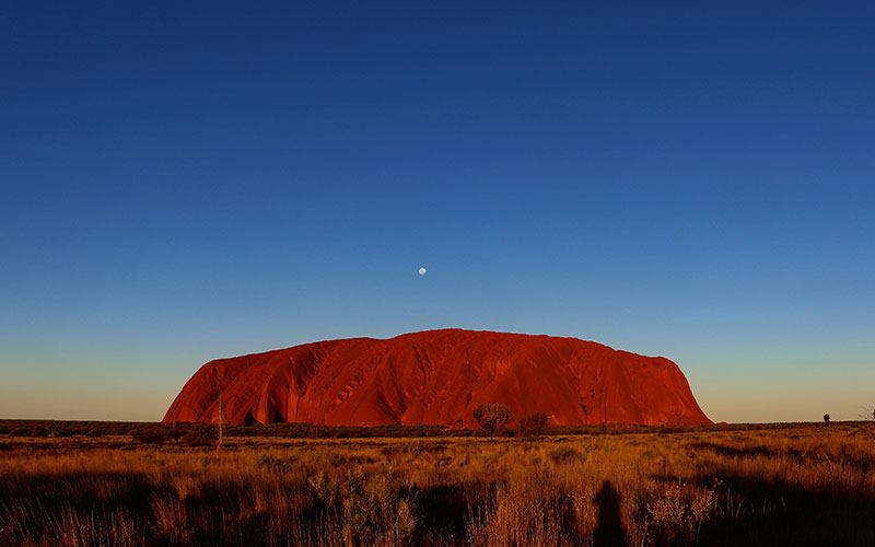 Sunset over Ayres Rock with the moon above it