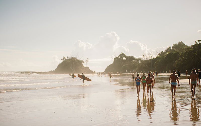 Surfers and beachgoers in Byron Bay